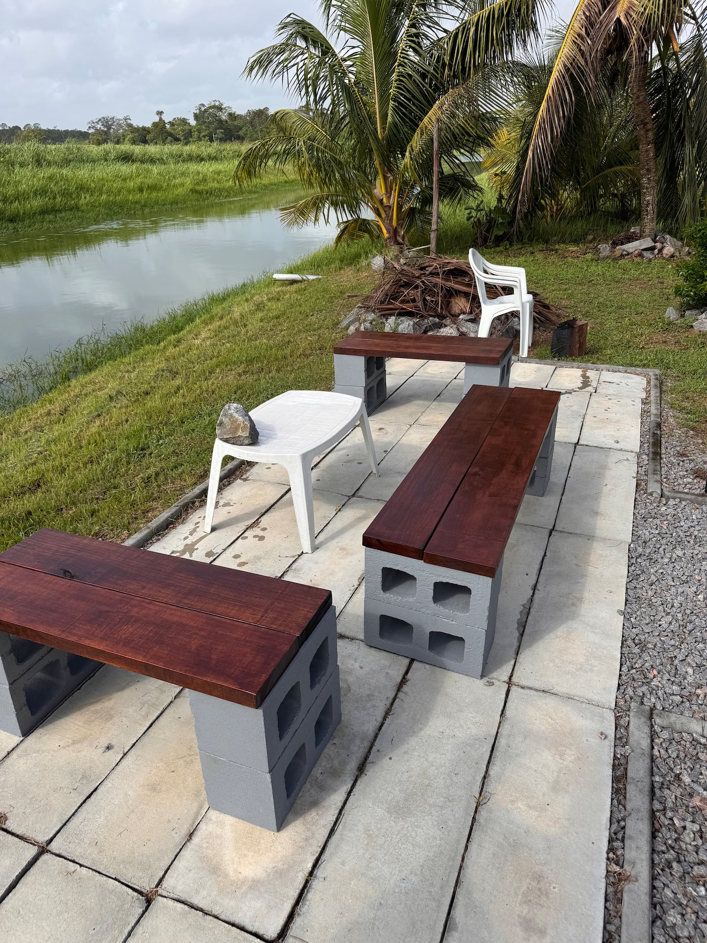 Zitplek met houten banken aan het water naast de villa