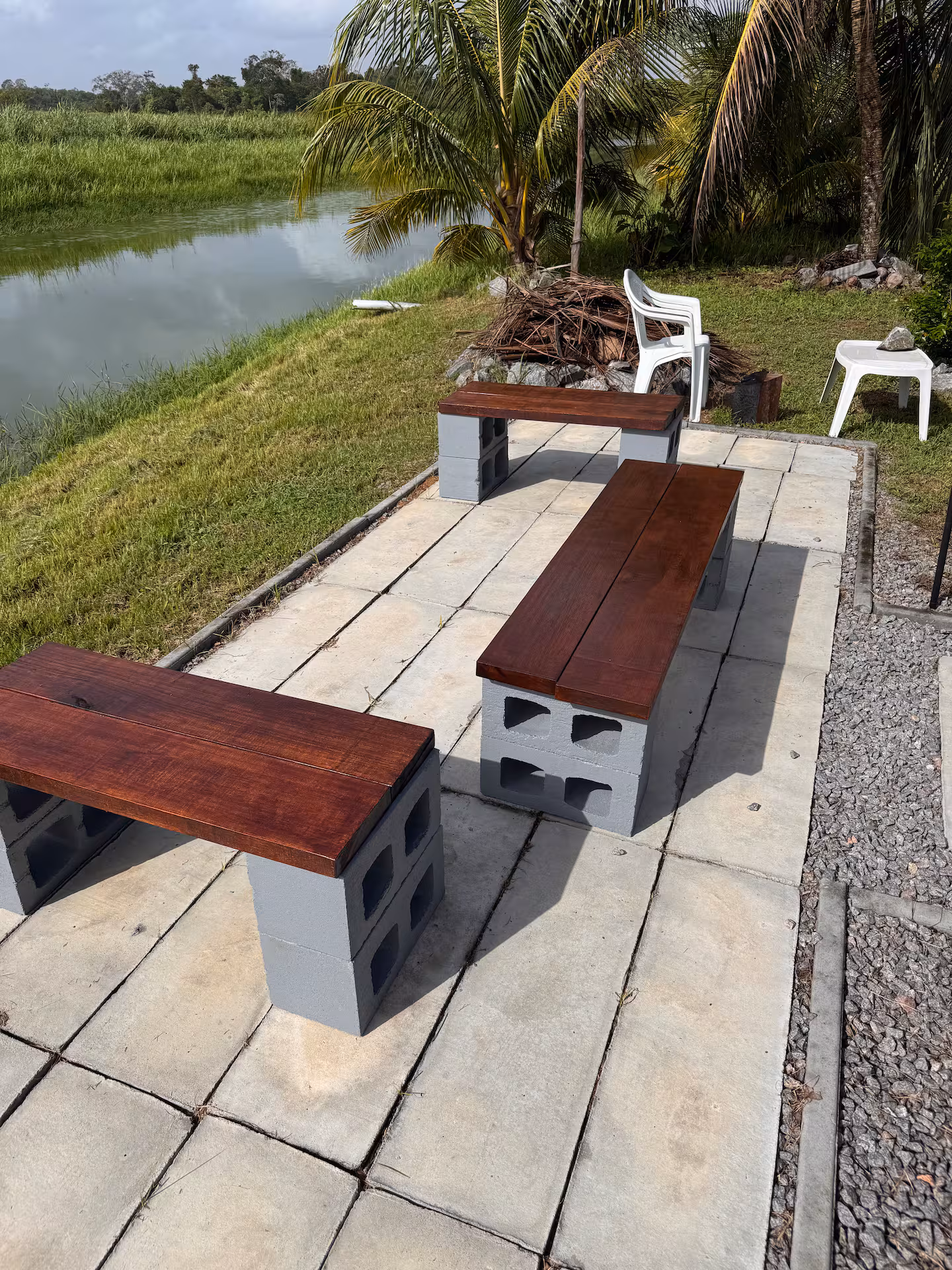 Zitplek met houten banken aan het water naast de villa