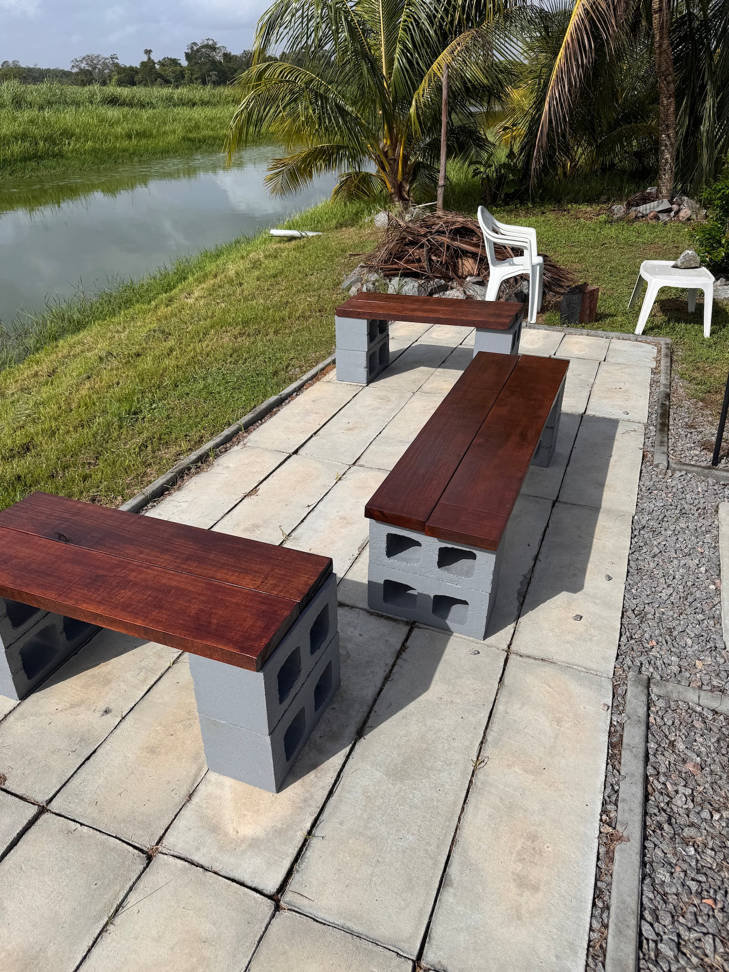 Zitplek met houten banken aan het water naast de villa